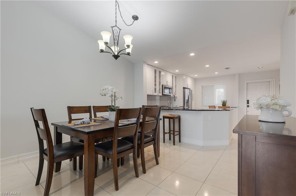 7766 Emerald Circle, Unit R203 Naples, FL 34109 - Photo 13 of 30 Dining area with light tile patterned floors, recessed lighting, and a chandelier