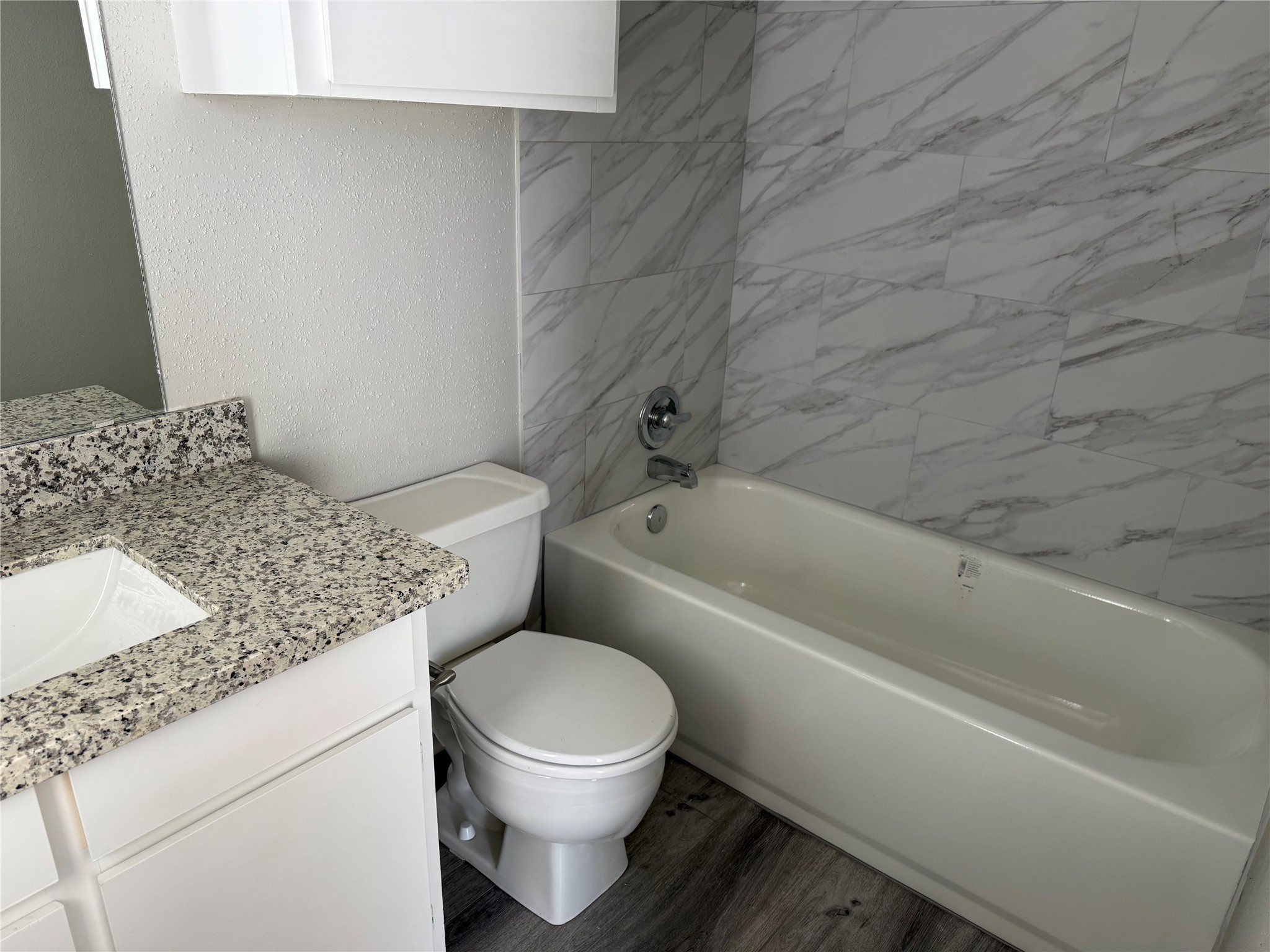 7575 Cambridge Street, Unit 2804 Houston, TX 77054 - Photo 33 of 38 a bathroom with a granite countertop toilet and a bathtub