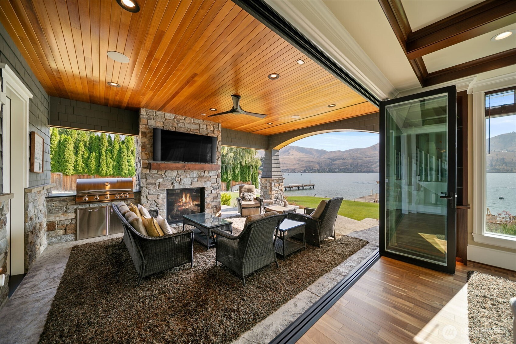 58 Key Bay Lane Chelan, WA 98816 - Photo 18 of 40 a living room with fireplace furniture and a floor to ceiling window