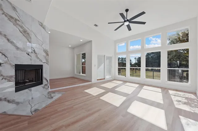 a view of an empty room with a fireplace and wooden floor
