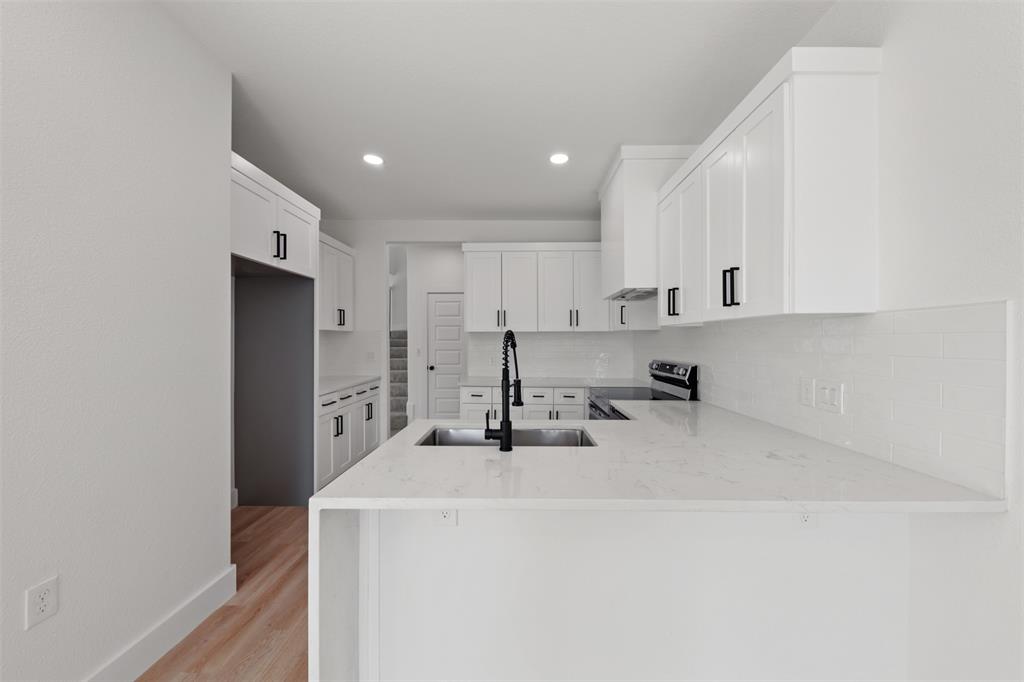 1412 North Crosspointe Street Duncanville, TX 75137 - Photo 8 of 24 a kitchen with a sink a stove and a refrigerator