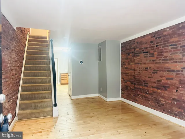 a view of an empty room with stairs and door