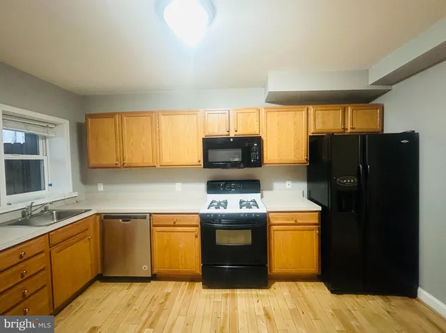 a kitchen with a sink a stove top oven and refrigerator