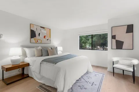 a bedroom with a bed and a painting on the wall