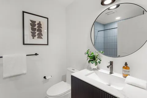a bathroom with a sink vanity mirror and toilet
