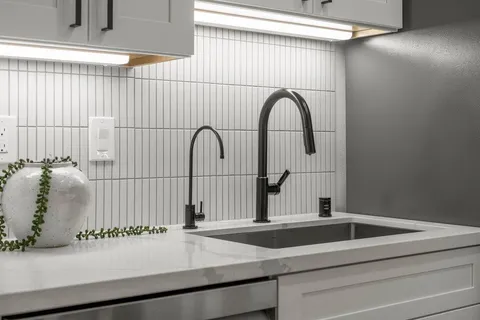 a close view of a sink and mirror with bathtub