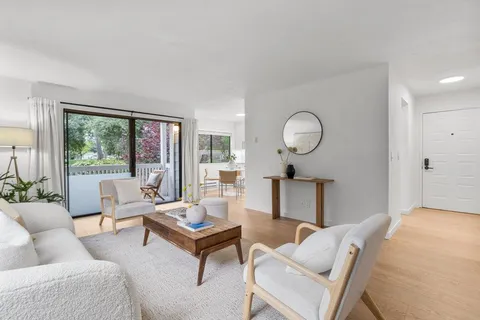 a living room with furniture a lamp a rug and a large window