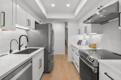 a kitchen with stainless steel appliances granite countertop a sink stove and refrigerator