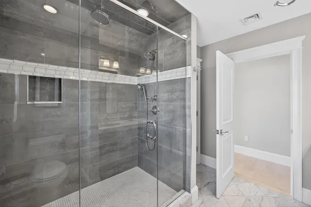 a bathroom with a glass shower door and a toilet