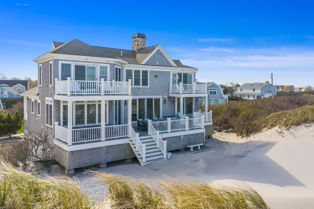 a view of a house with a wooden deck and a yard