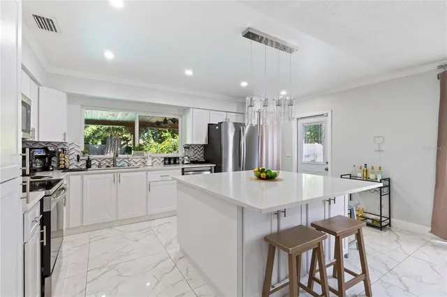 a kitchen with kitchen island a table and chairs in it