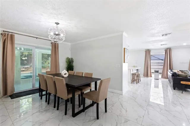 a view of a dining room with furniture and chandelier