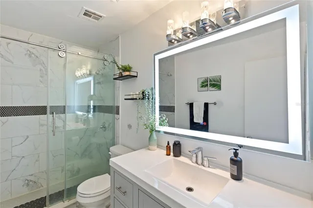a bathroom with a sink mirror toilet and shower