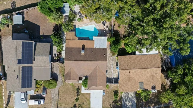 an aerial view of residential houses with outdoor space and trees