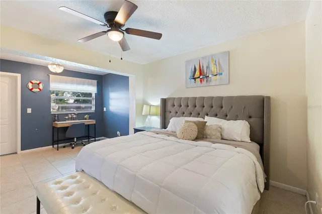 a bedroom with a large bed and a chandelier
