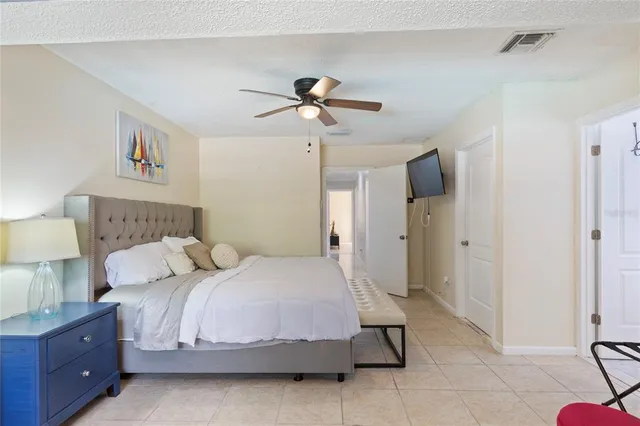 a bedroom with a bed and a lamp on the dresser