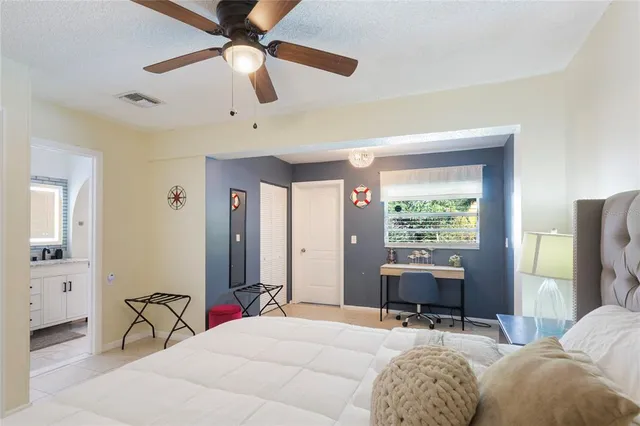 a bedroom with a bed desk and a window