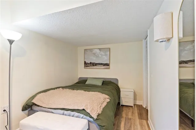 a bedroom with a bed and a painting on the wall