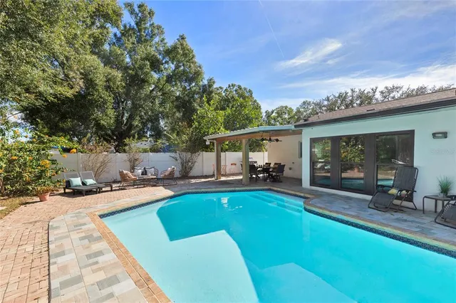 a view of a house with swimming pool and sitting area