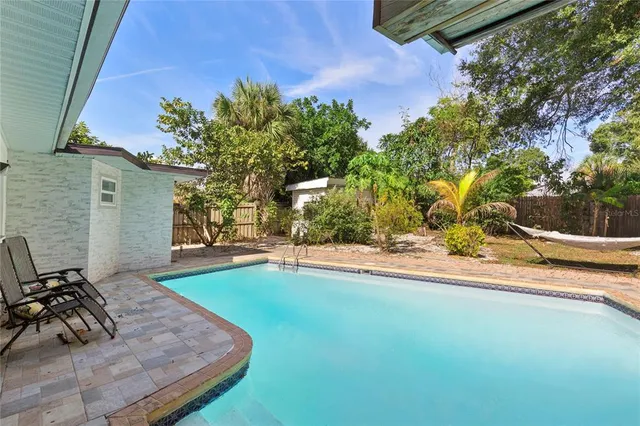 a view of a house with pool and sitting area