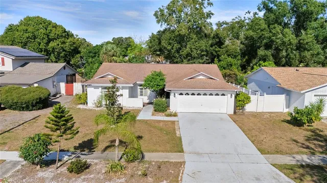 an aerial view of a house with a yard and trees