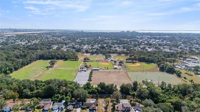 an aerial view of a city with lots of residential buildings ocean and mountain view in back