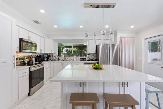 a kitchen with stainless steel appliances kitchen island granite countertop a sink and cabinets
