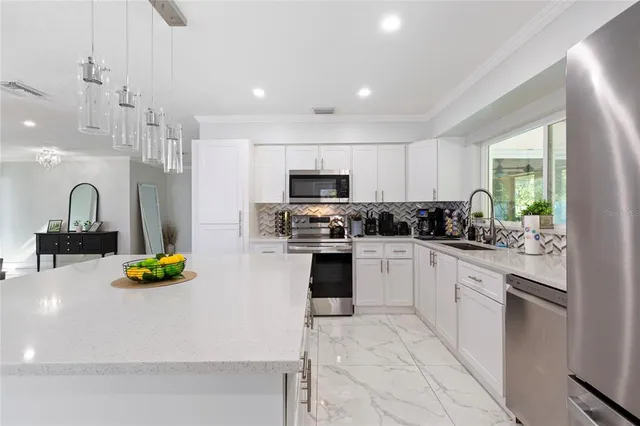 a kitchen with a sink a counter top space appliances and cabinets