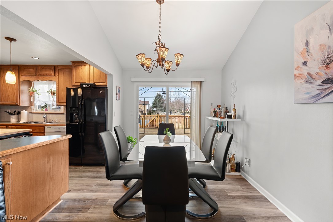 7094 Brandywine Road Parma Heights, OH 44130 - Photo 23 of 49 Dining area with a chandelier, sink, light wood-type flooring, and lofted ceiling