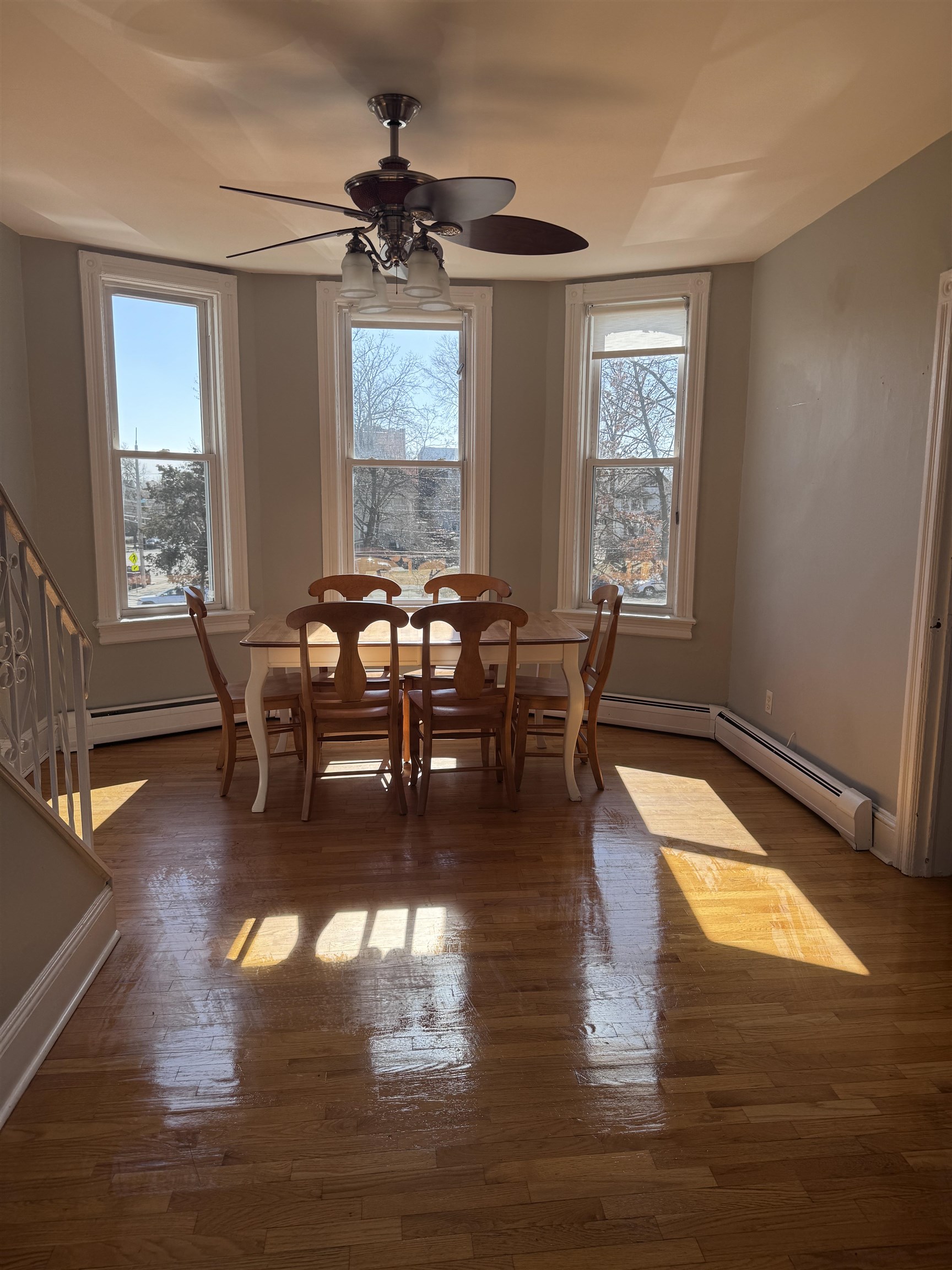 901 Avenue C, Unit 2 Bayonne, NJ 07002 - Photo 6 of 7 a dining room with wooden floor a chandelier a glass table and chairs