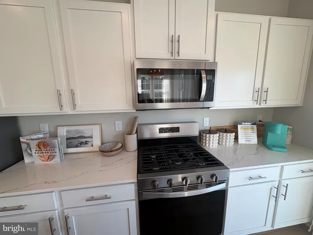 a kitchen with white cabinets and appliances