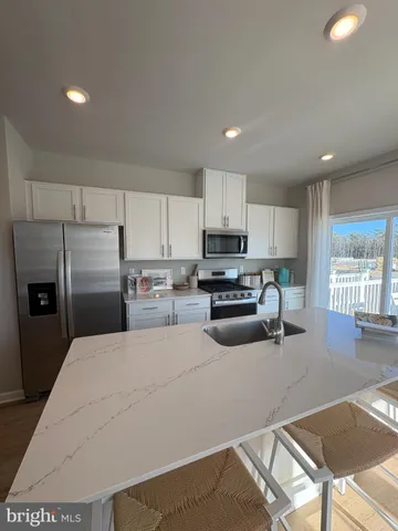 a kitchen with granite countertop a refrigerator sink and stove