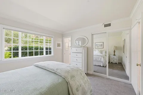 a bedroom with a bed and a large window