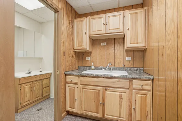 a bathroom with cabinets a sink and a window