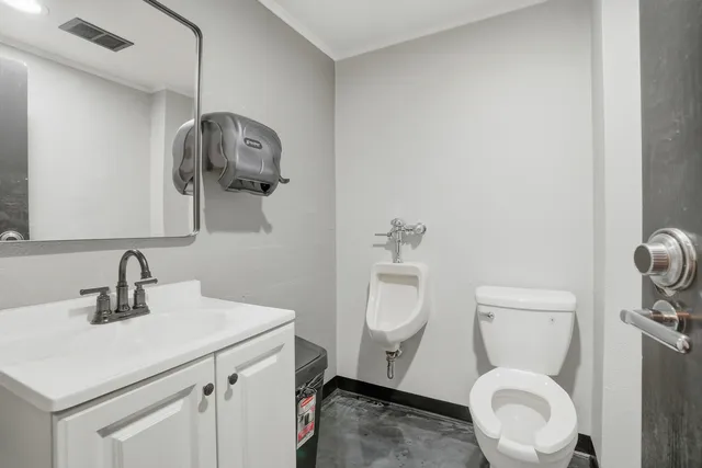 a bathroom with a toilet sink and mirror