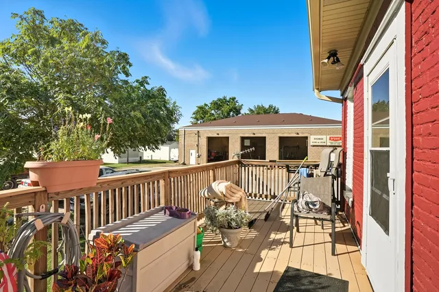 a balcony with wooden floor table and chairs