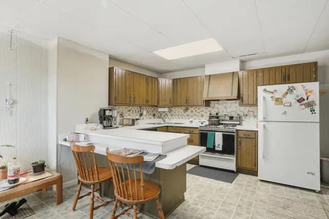 a kitchen with stainless steel appliances a stove a sink dishwasher and white refrigerator