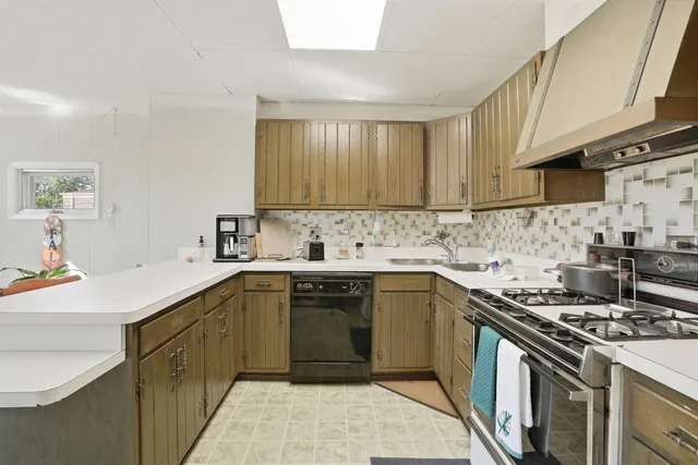 a kitchen with stainless steel appliances a sink stove and cabinets
