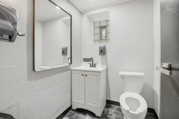 a bathroom with a toilet a sink and mirror
