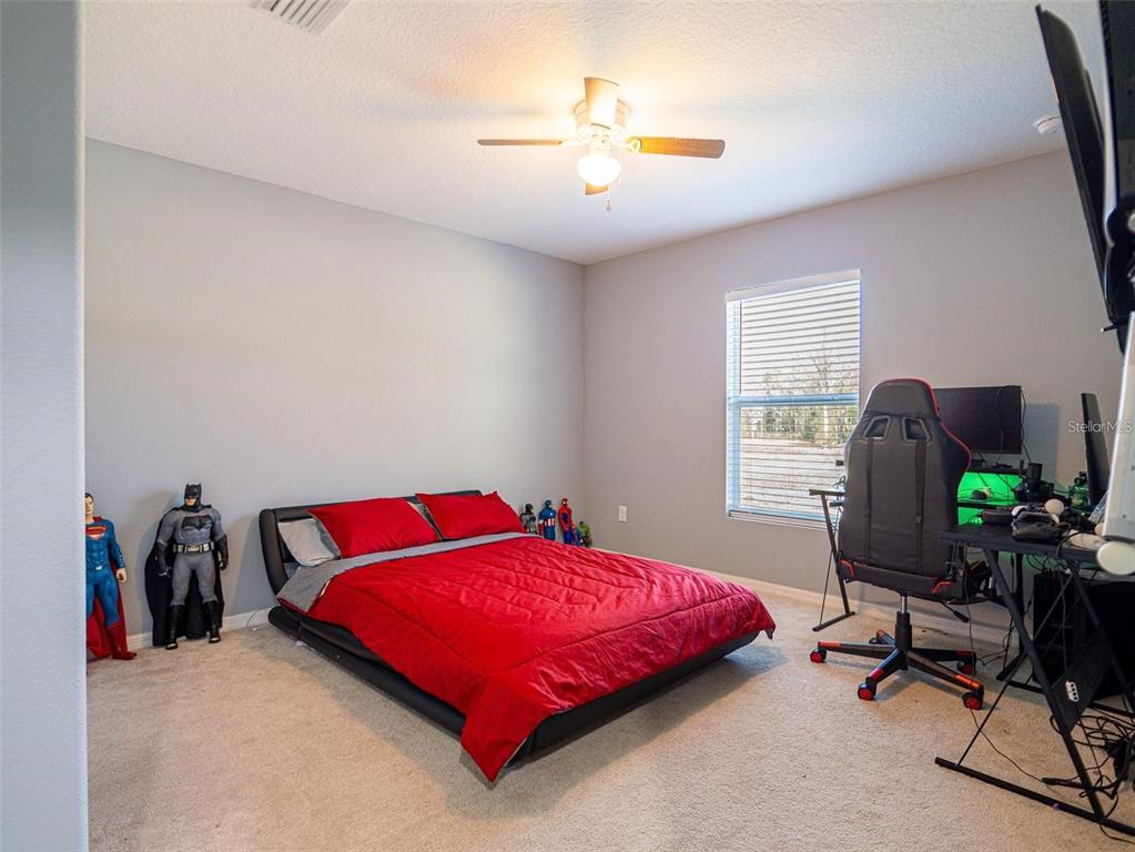 10688 Southwest 129th Terrace Road Dunnellon, FL 34432 - Photo 26 of 35 a bedroom with a bed and a chair