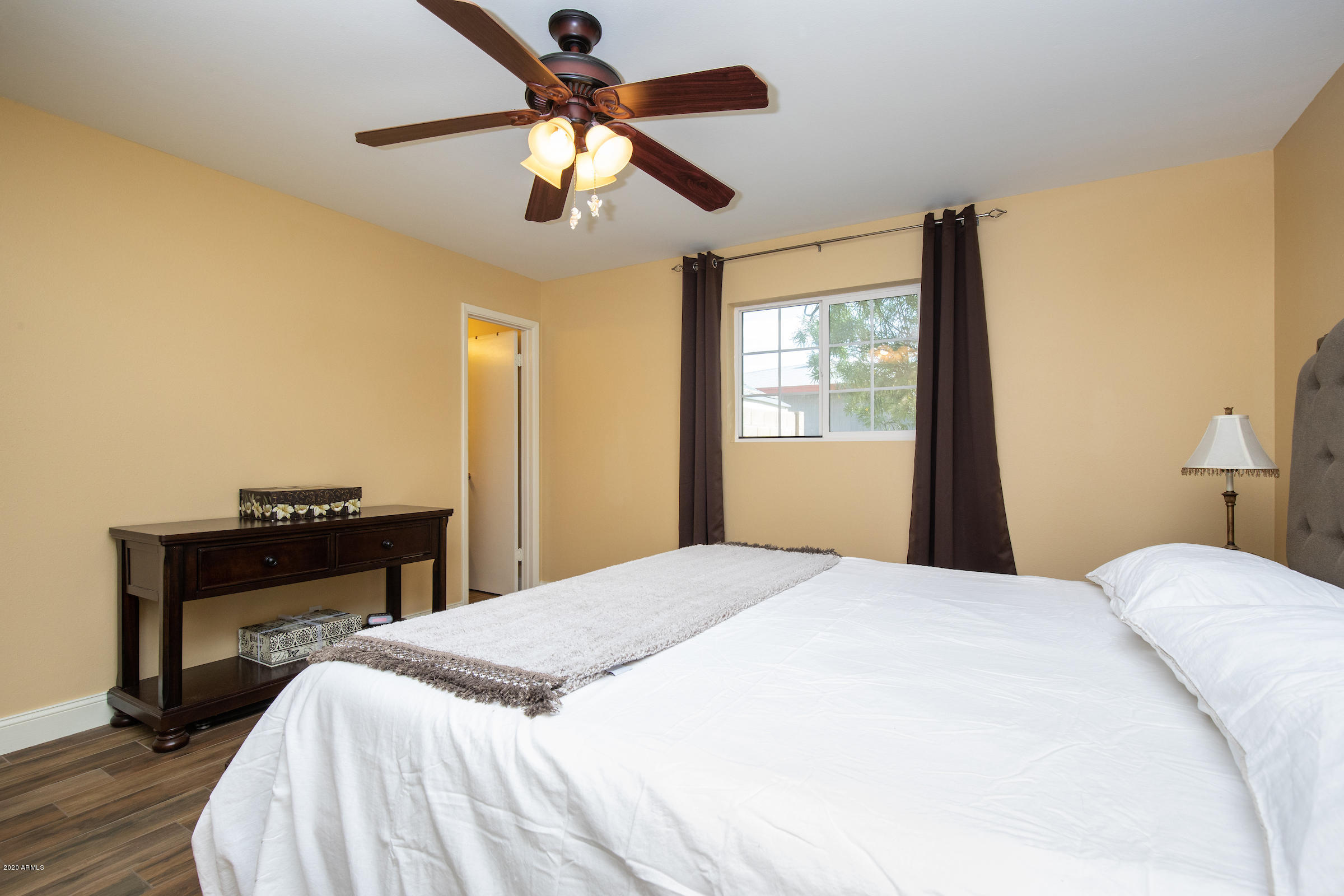 5320 East Decatur Street Mesa, AZ 85205 - Photo 18 of 34 a bedroom with a bed and a chandelier
