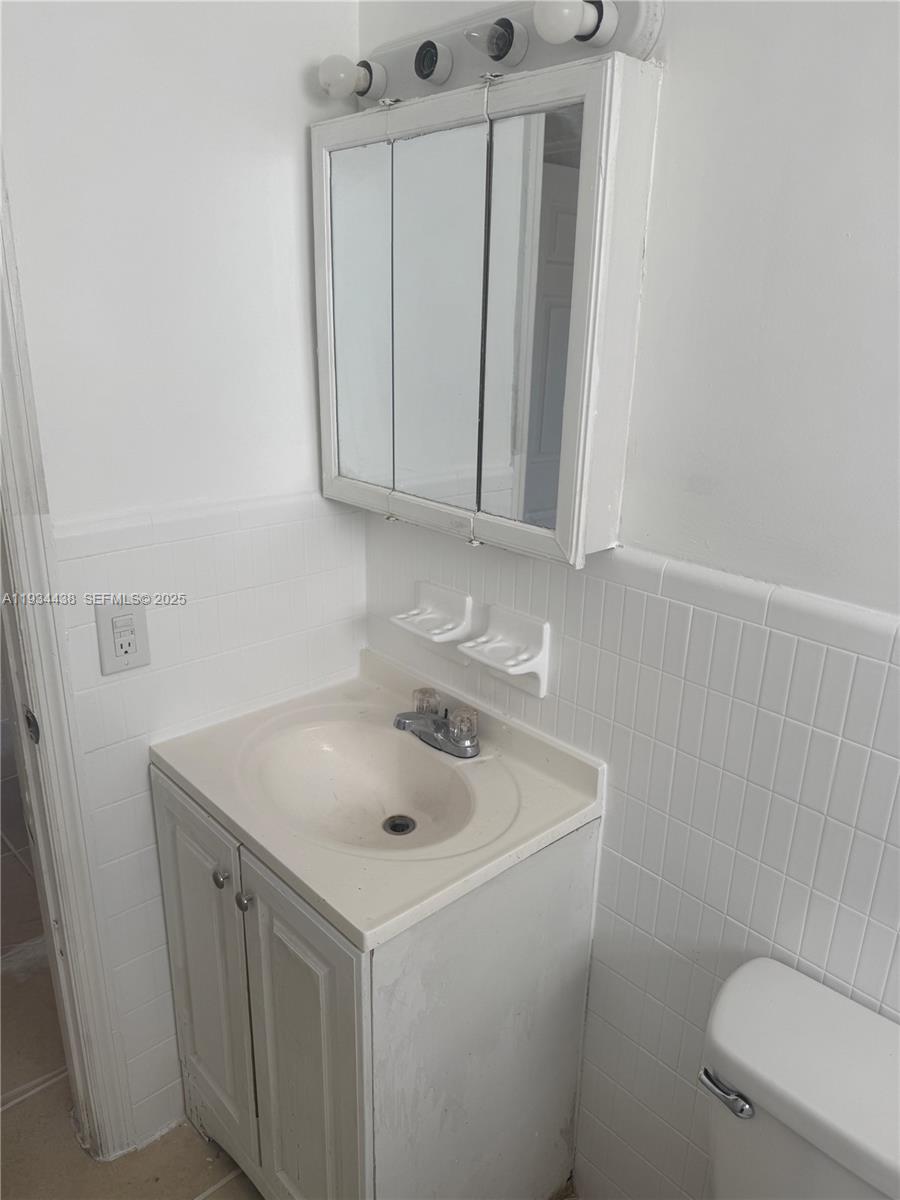621 Southwest 15th Avenue, Unit 4 Miami, FL 33135 - Photo 15 of 15 a bathroom with a sink a toilet and a mirror