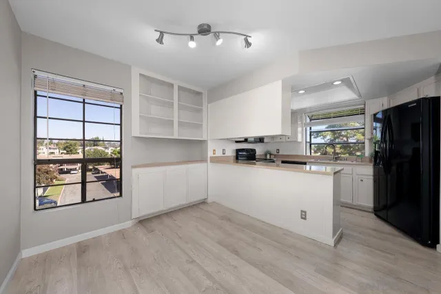 a kitchen with white cabinets and appliances
