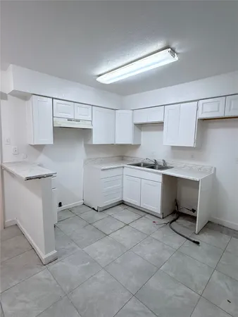 a view of a kitchen with white cabinets