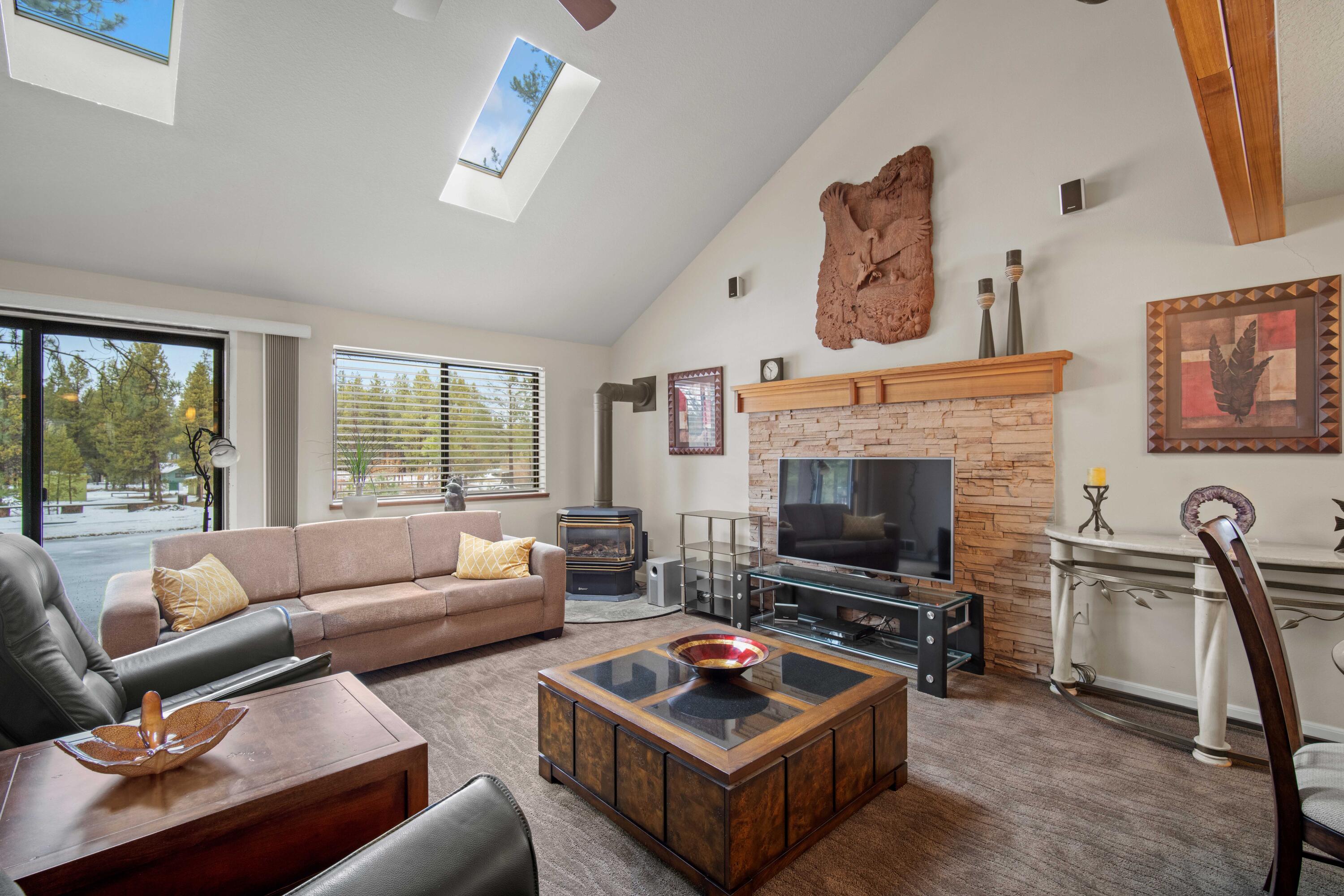 56019 Snow Goose Road Bend, OR 97707 - Photo 1 of 32 a living room with furniture a flat screen tv and a fireplace