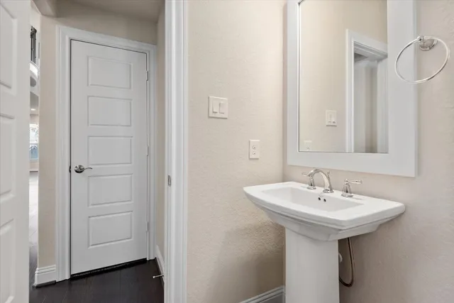 a kitchen with stainless steel appliances granite countertop a sink a stove a refrigerator and white cabinets with wooden floor