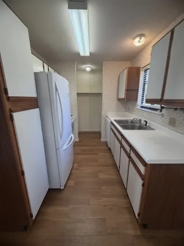 a kitchen with sink a refrigerator and a stove