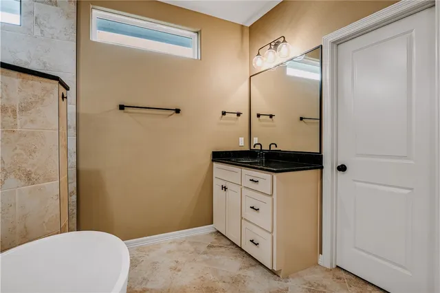 a bathroom with a granite countertop sink mirror vanity and toilet