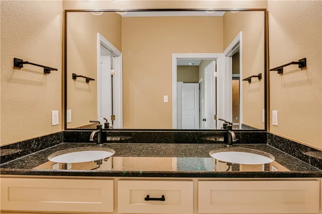 a bathroom with a granite countertop sink and a mirror