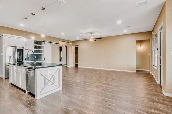 a large kitchen with stainless steel appliances kitchen island granite countertop a stove and a sink